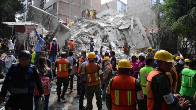 Los equipos de rescate frente a un edificio colapsado.