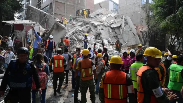 Los equipos de rescate frente a un edificio colapsado.