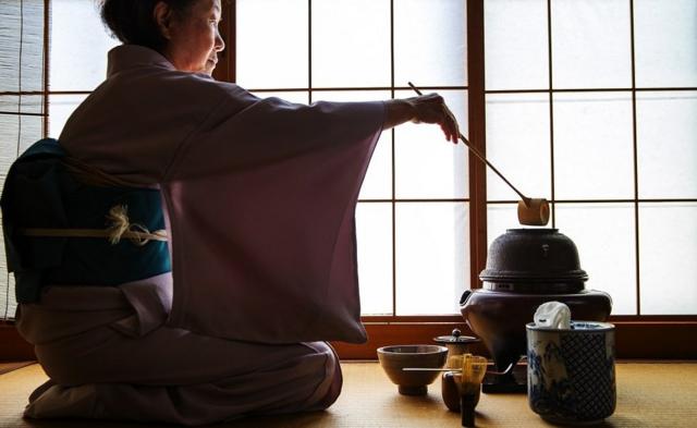 Une femme célébrant la cérémonie traditionnelle japonaise du thé