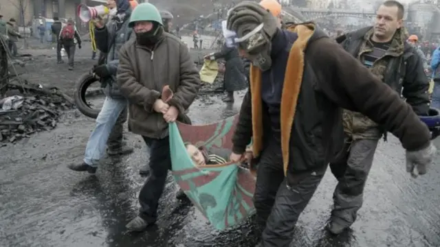 Активисты несут раненого