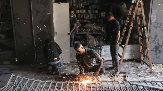 ગાઝામાં પોતાની દુકાન વ્યવસ્થિત કરતા દુકાનદાર