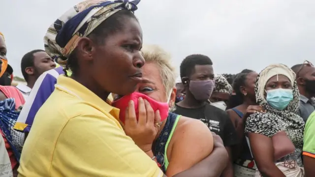 A woman cries as she waits for her son to arrive in Pemba on April 1, 2021, from the boat of evacuees from the coasts of Palma.