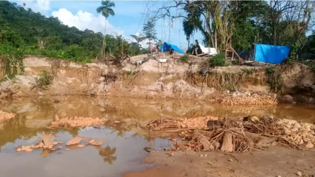 Cratera com acampamentojogo que paga pix na horagarimpeiros ao fundo