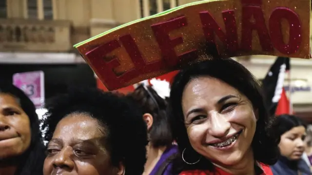 Mulher sorri com uma placa junto ao topo da cabeça, com os dizeres "Ele não",betsbola com apostaseventobetsbola com apostascampanha do PTbetsbola com apostasSão Paulo