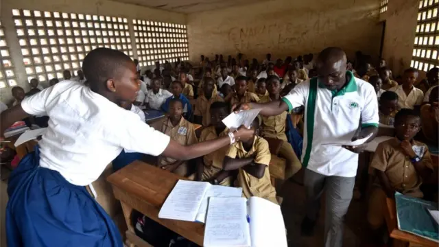 Wani malami yana mayar wa da dalibai aikin da ya ba su a ajin makarantar da aka ga gawar wani yaro dan shekara 14 a birnin Abidjan na Ivory Coast.