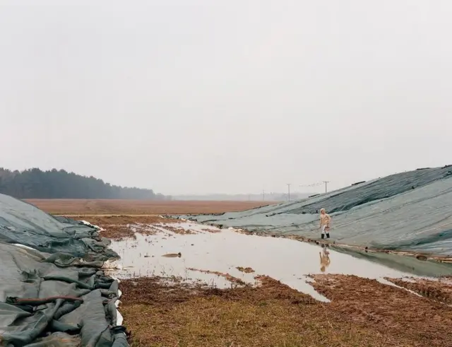 A girl walks around a body of water