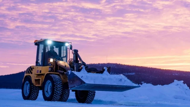 عامل يقود معدة ثقيلة