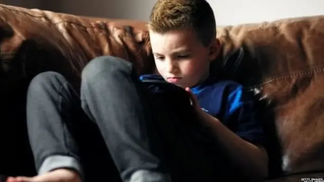 लेटकर मोबाइल चलाता बच्चा