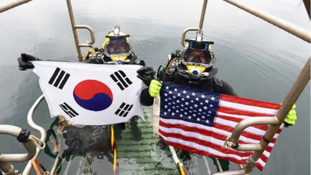 지난 6월 15일 경남 창원 진해만 일대에서 열린 한미 연합 구조전 훈련에서 한미 양국 구조대원들이 손상 함정 긴급 복구 훈련 종료 후 자국 국기를 들어보이고 있다