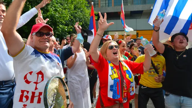 People celebrate after Australian court quashes visa cancellation for Novak Djokovic on 10 January 2022 in Melbourne, Australia