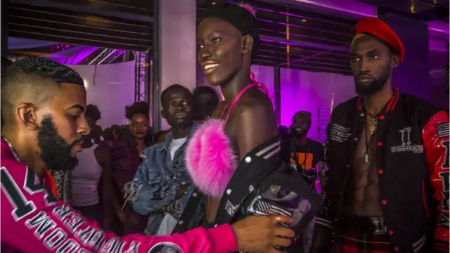 Le designer et styliste américain Mickey Freeman (à gauche) ajoute sa touche spéciale à ses créations lors de la Semaine de la mode de Dakar à Dakar, au Sénégal.