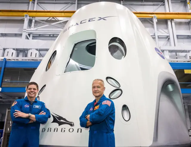 Bob Behnken y Doug Hurley frente al módulo Dragon