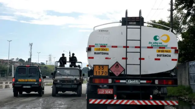 Militares em jipe ao lado de caminhão de combustível