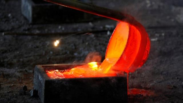內蒙古一個冶煉廠，工人把稀土金屬鑭熔化後注入模具。