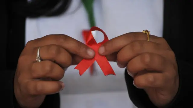 এইচআইভি প্রতিরোধে সচেতনতা বাড়াতে লাল ফিতা একটি প্রতীক, কাঠমুন্ডু, নেপাল, ০১-১২-২০১৬।
