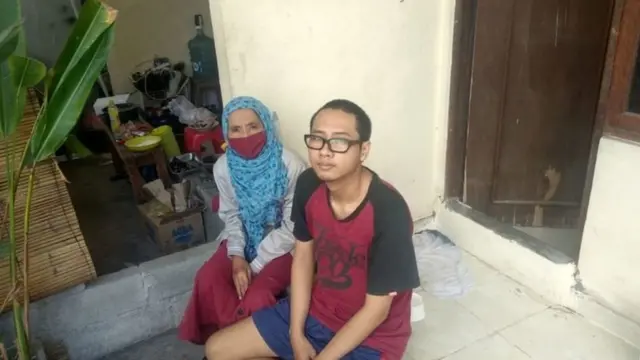 Endang Isnanik dan anaknya duduk di depan kamar kos yang disewa di Denpasar, Bali.