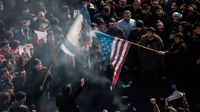Manifestantes quemando banderas