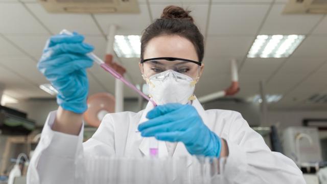 Científica en un laboratorio hace pruebas con una pipeta