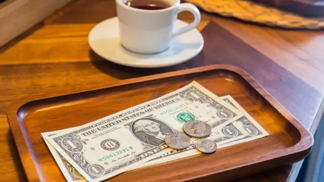 찻잔과 미 달러와 동전