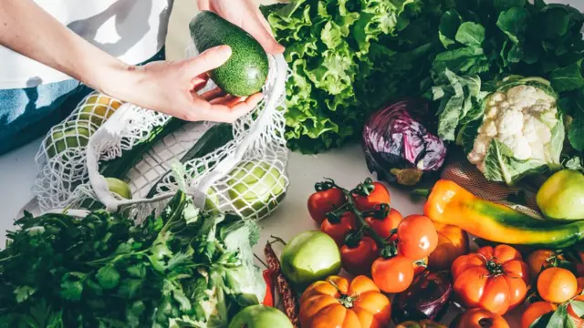 Pessoa manuseando legumes e verduras variados