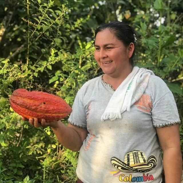 Ana Yudith, habitante de una de las comunidades alcanzadas por el proyecto, sosteniendo en su mano un fruto de cacao