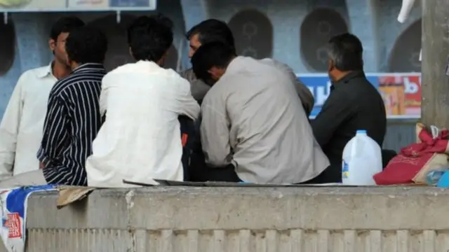 গল্প মশগুল একদল অভিবাসী শ্রমিক।