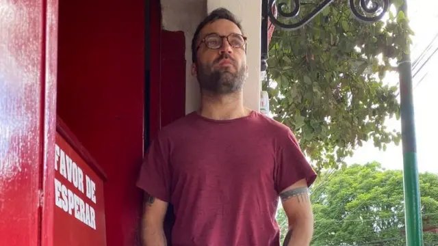 Eduardo Rabasa recostado a una pared en la calle.