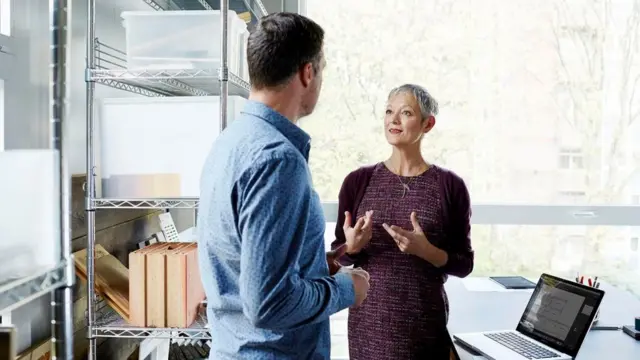 Dos personas hablando en una oficina