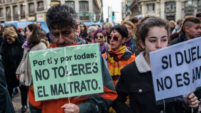 hombre sostiene pancarta en marcha feminista