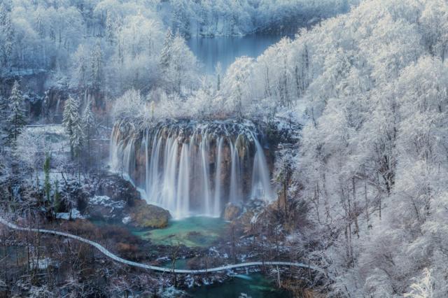 Floresta coberta de neve e cachoeira