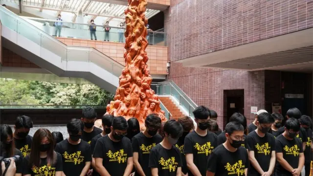 대학생들이 '수치의 기둥' 앞에서 묵념하고 있다