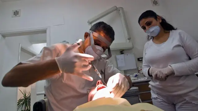 Una persona a la que el dentista le está inyectando anestesia