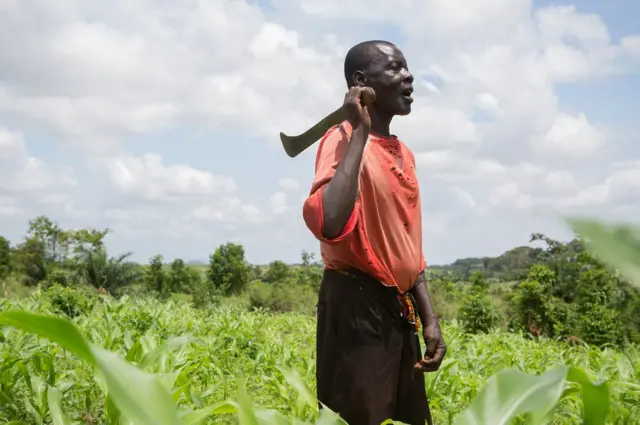 Nana Agya Kwao stands in a field
