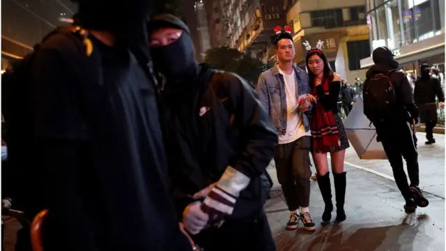 黑衣人与庆祝圣诞的市民一同出现街头。