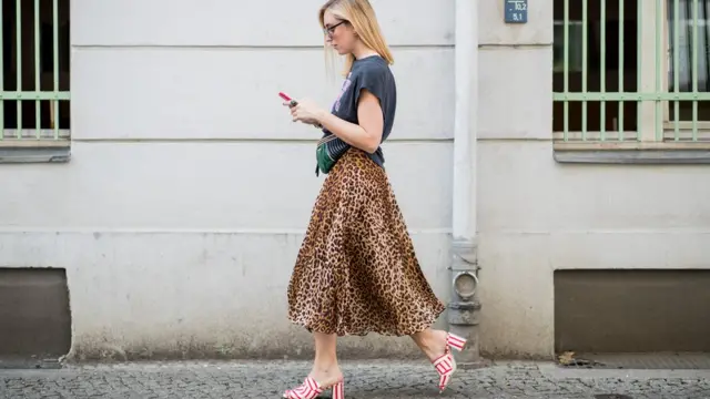 Девојка шета и држи мобилни телефон