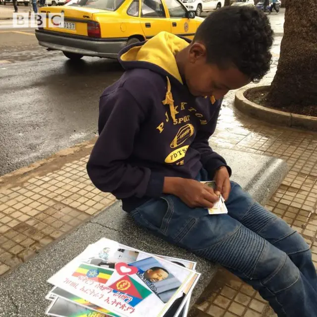 Wiil yar oo iibiya sawirada madaxda iyo calamada