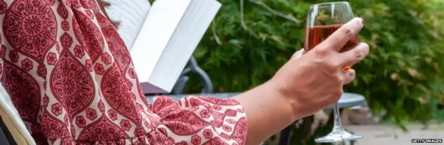 A woman drinking in a garden