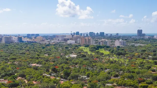 Una vista aérea de Coral GablesLe quartier commercial de Coral Gables (centre-ville), avec ses immeubles à plusieurs étages, contraste avec ses quartiers de maisons individuelles bordés d'arbres.