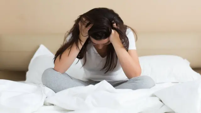 Joven sujetándose la cabeza