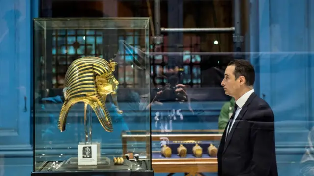 A man views the golden sarcophagus of the Pharaoh Tutankhamun, on display at the Egyptian Museum in the capital Cairo on November 28, 2017. The Egyptian museum celebrated on November 28, 2017 the 115th anniversary of its establishment, displaying for the first time some 60 golden pieces of the chariot of King Tutankhamun among its other 120 thousand artefacts.