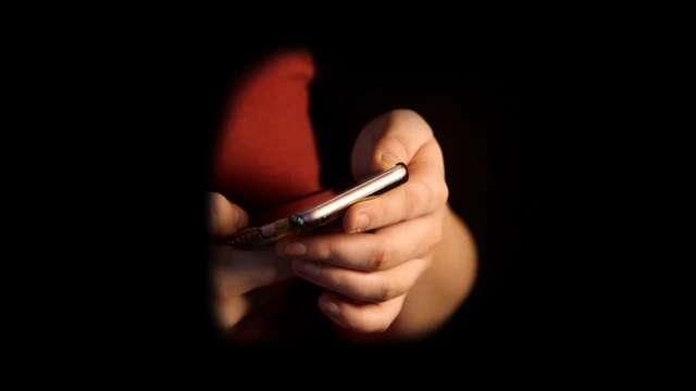 Mujer sosteniendo celular en sus manos.