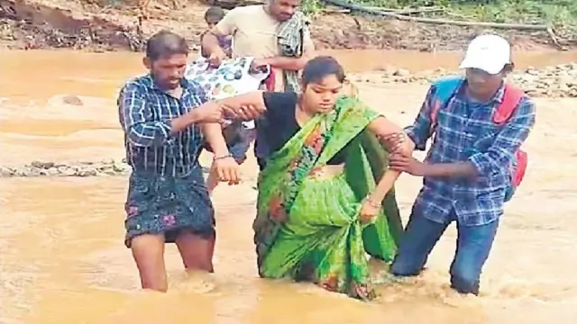 వాగు దాటుతున్న గర్భిణి