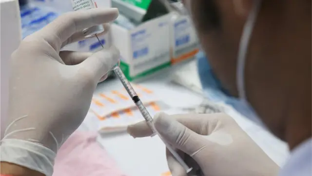 Cientista manuseando vacina da Astrazeneca