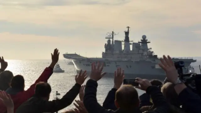 当地民众向"卓越"号航母告别。