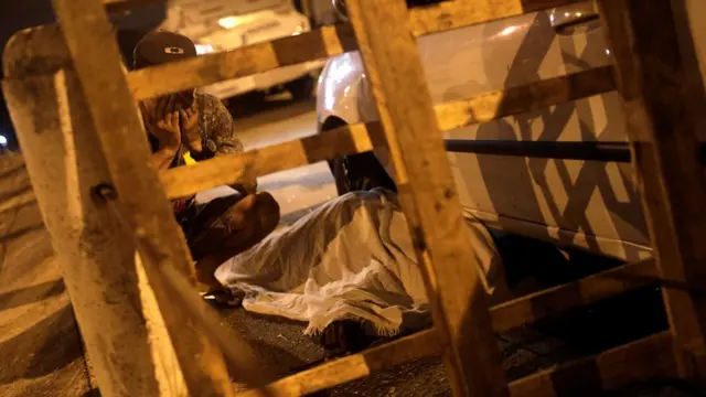 Un hombre llorando la muerte de Jean da Silva.