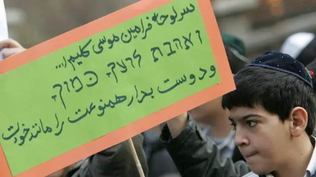 نوجوان یهودی ایرانی پلاکاردی با مضمون نوع دوستی در دست دارد
