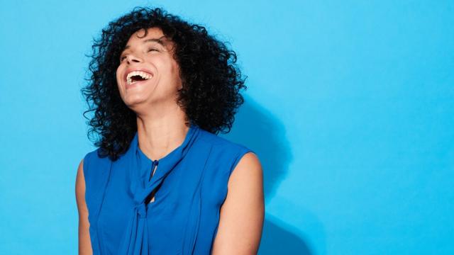 Mulher sorrindo na frentedicas para apostar no basqueteparede azul