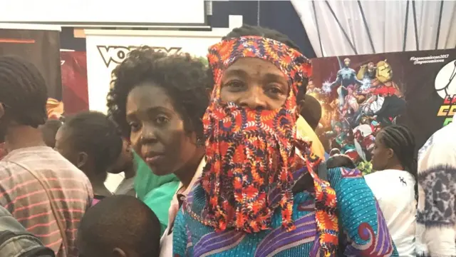 Woman wey put ankara for face.