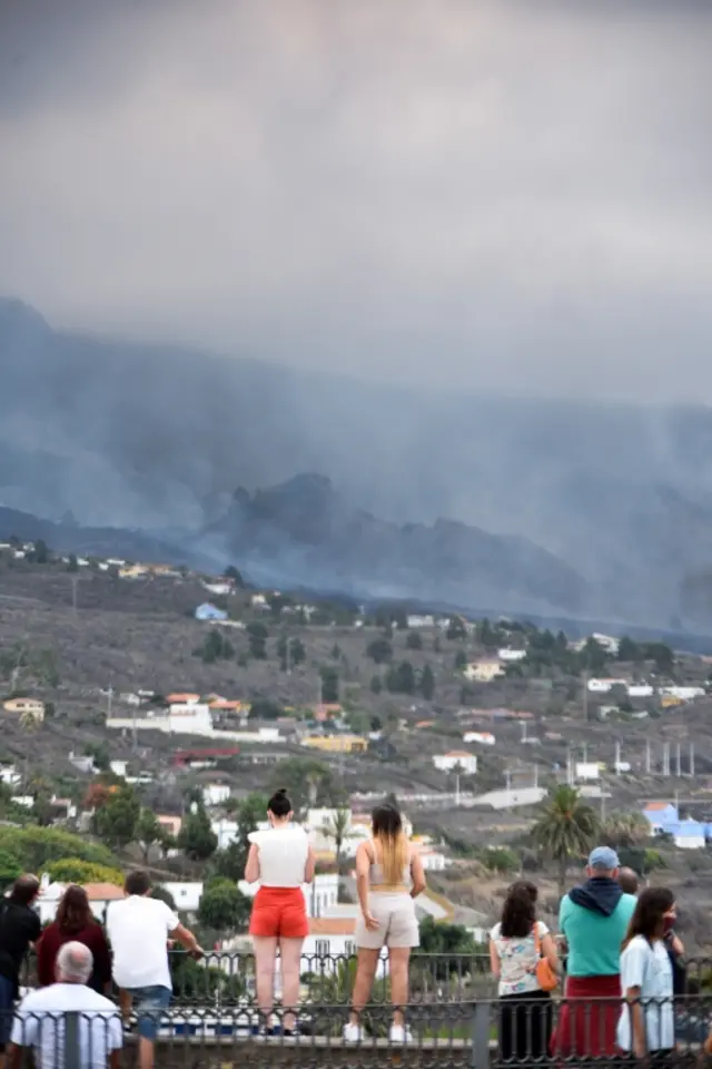 Personas observan la columna de humo del volcán La Palma, Canarias.