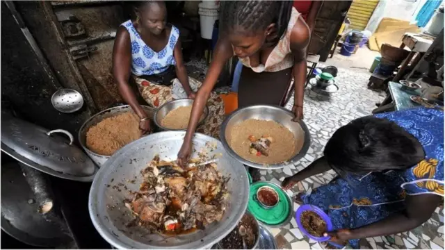 Des femmes préparent du riz au poisson